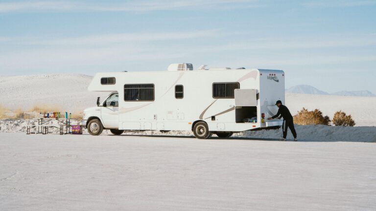 man outside his Class C RV set up for full time living