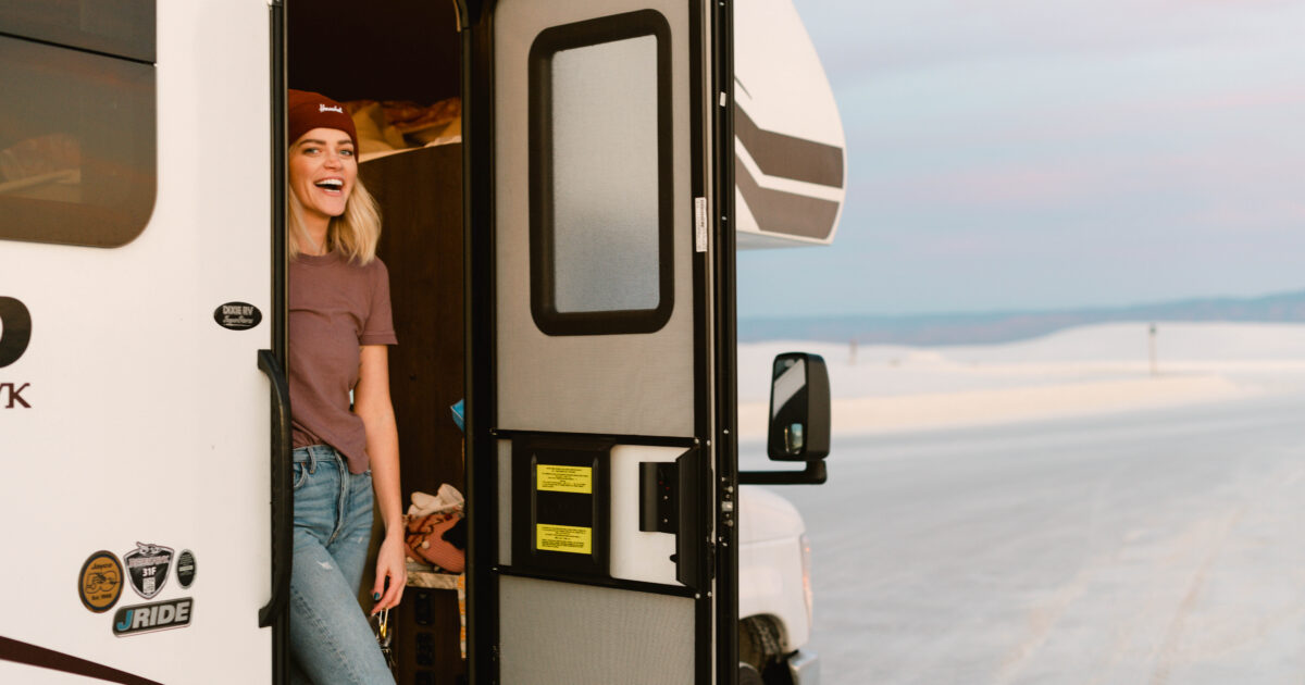 A woman stands in the door of her Class C RV rental