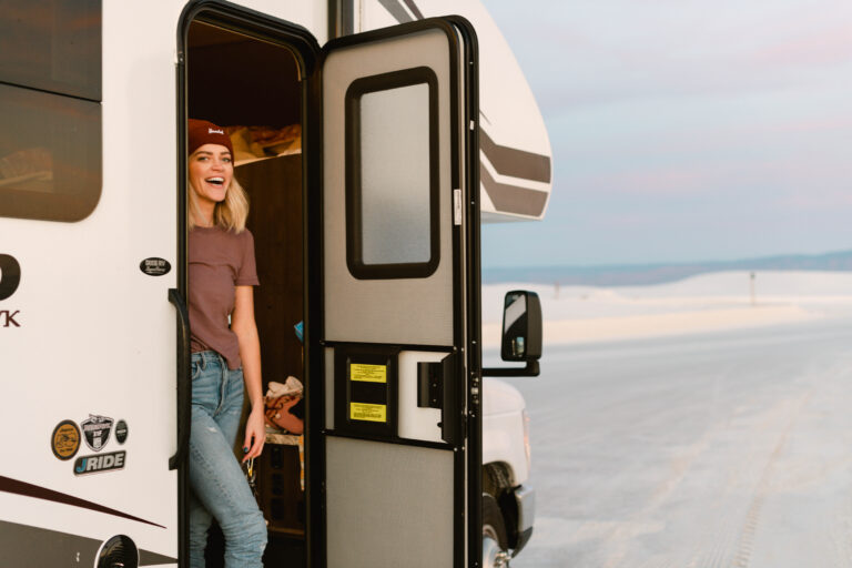 A woman stands in the door of her Class C RV rental