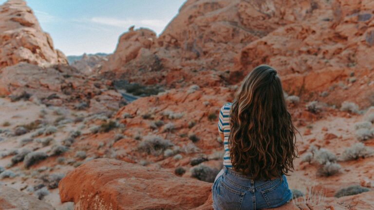 A woman sits overlooking the red rocks of Valley of Fire State Park in Nevada