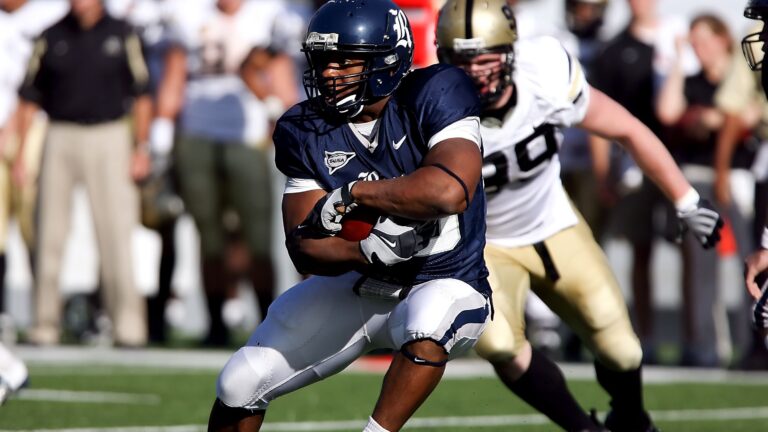 College football players run with the ball